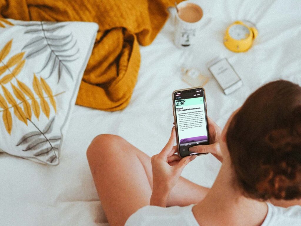Tjej sitter i säng och läser om Digital Marknadsföring hos SteadyGo