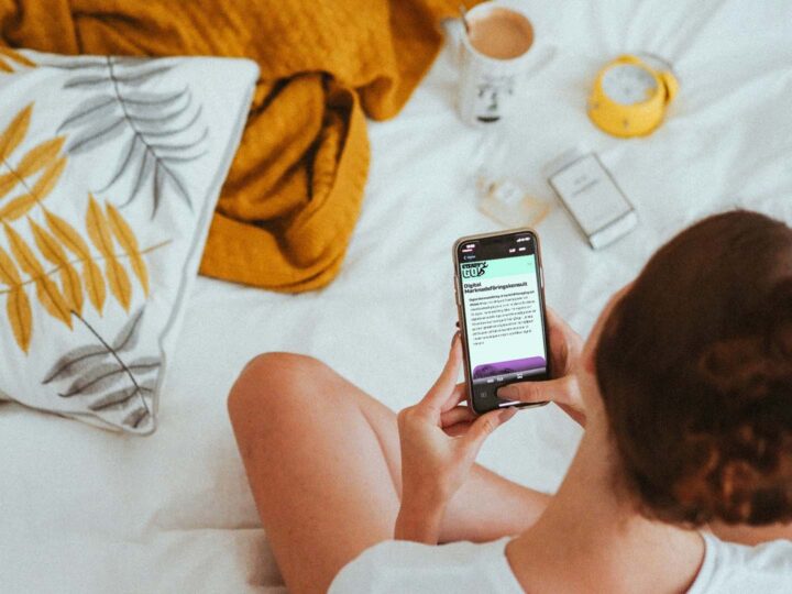 Tjej sitter i säng och läser om Digital Marknadsföring hos SteadyGo